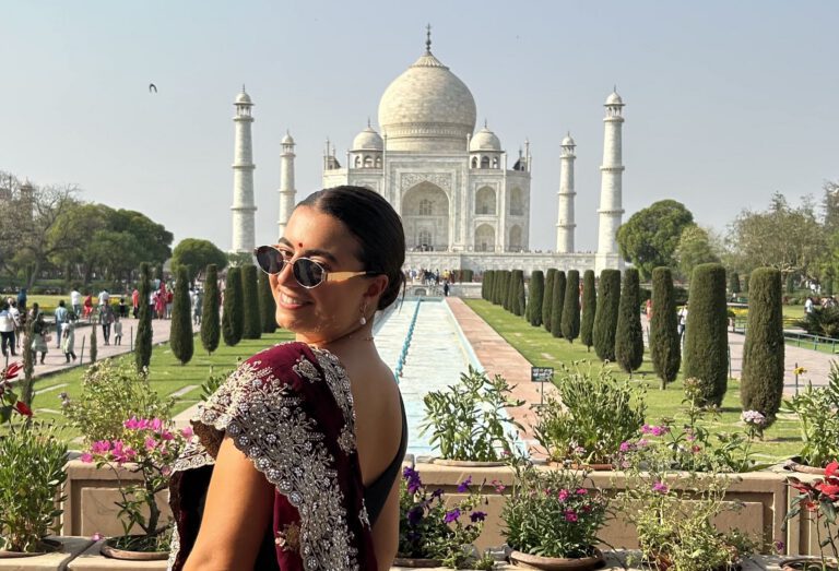 A solo female traveller smiling in front of the Taj Mahal on Contiki India Review