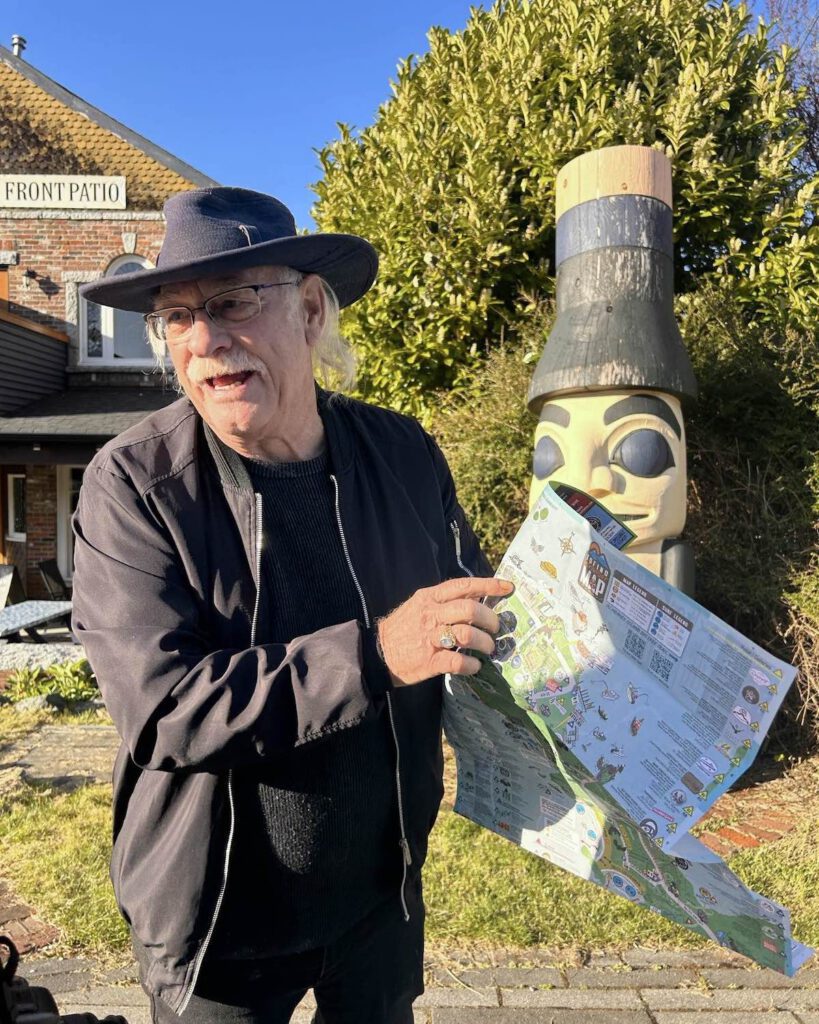 Crazy Ron holding a map of Tofino town BC in the spring
