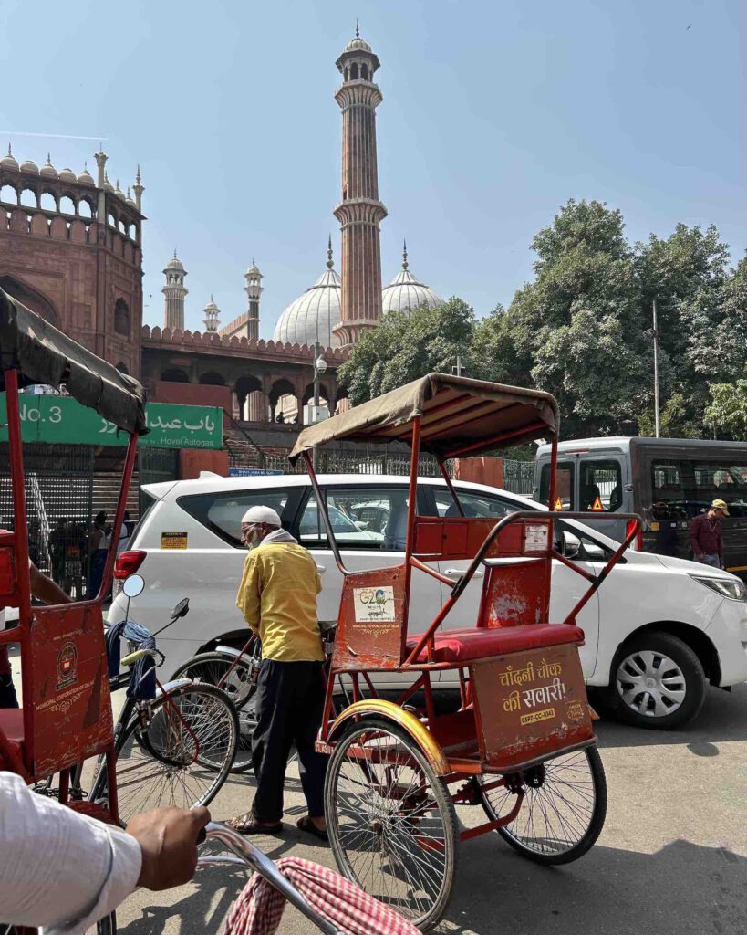 Cycle rickshaw on the busy streets of Old Delhi with Jama Masjid mosque in the background India