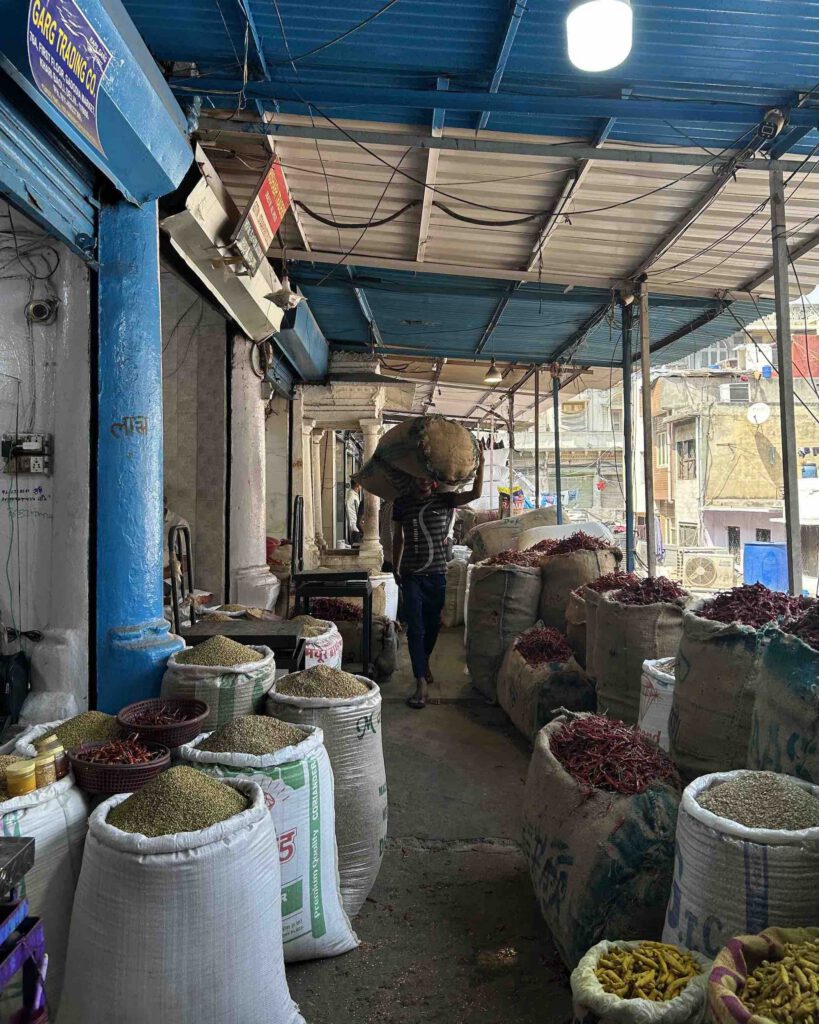 A man carrying a bag of spice through the market in Old Delhi