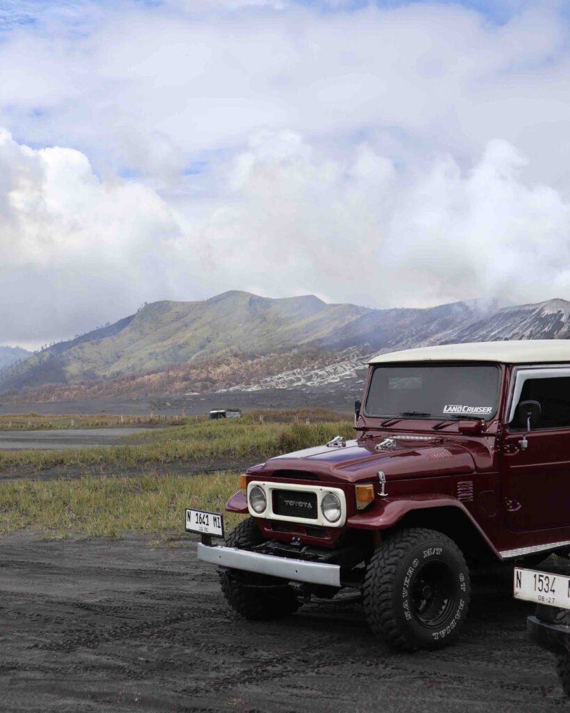 Red 4WD jeep on the sea of sand volcanic ash plain at Mount Bromo East Java
