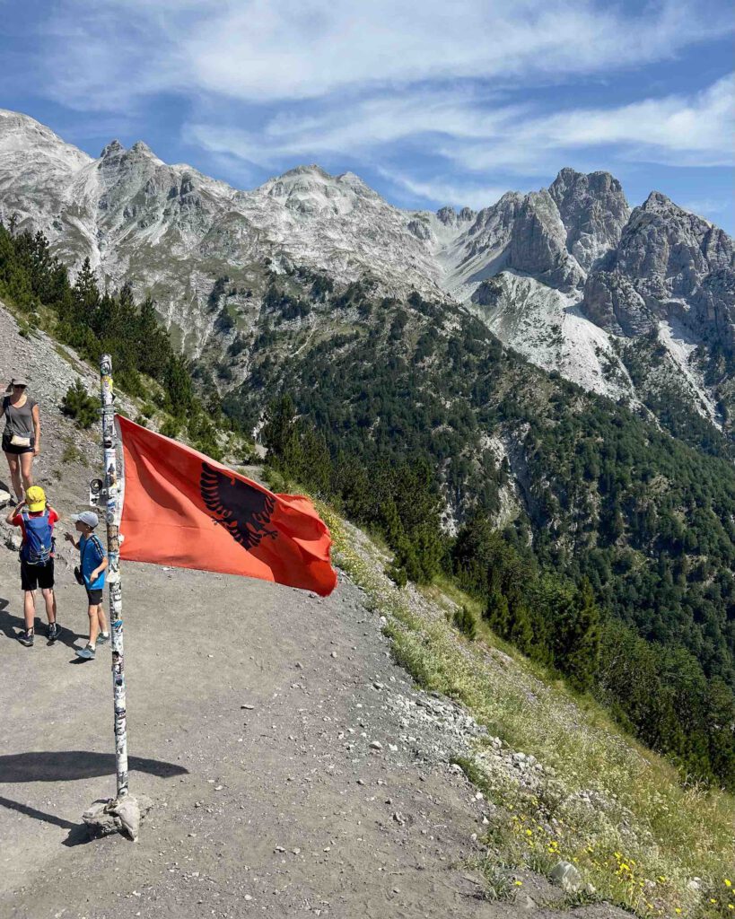 Albanian flag at the mountain pass highest point of the Valbona to Theth hike