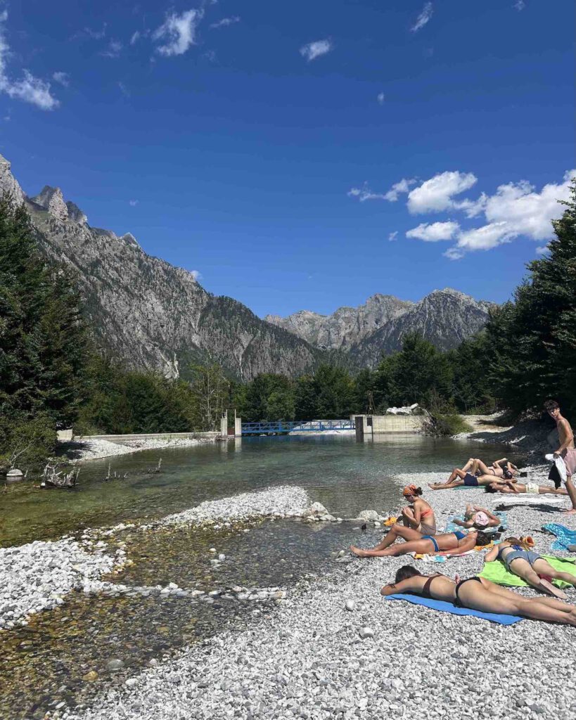 The turquoise river in Valbona where hikers relax before the Valbona to Theth hike