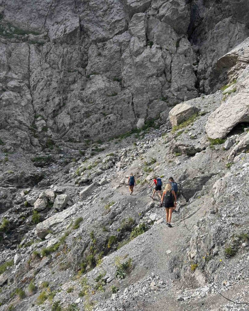 Beginner hikers climb a rocky section of the Valbona to Theth hike