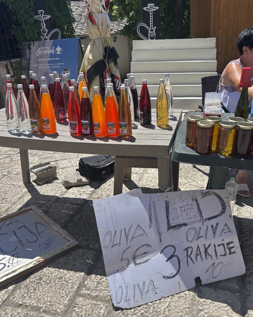 A local selling juice and olive oil at a market in Mostar